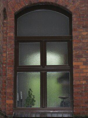 In eine Wand eingelassenes Fenster mit dunklen Fenstersprossen