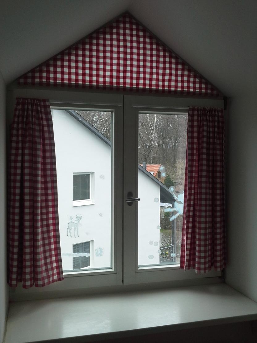 Dachfenster Blick aus einem Dachfenster mit roten Gardinen