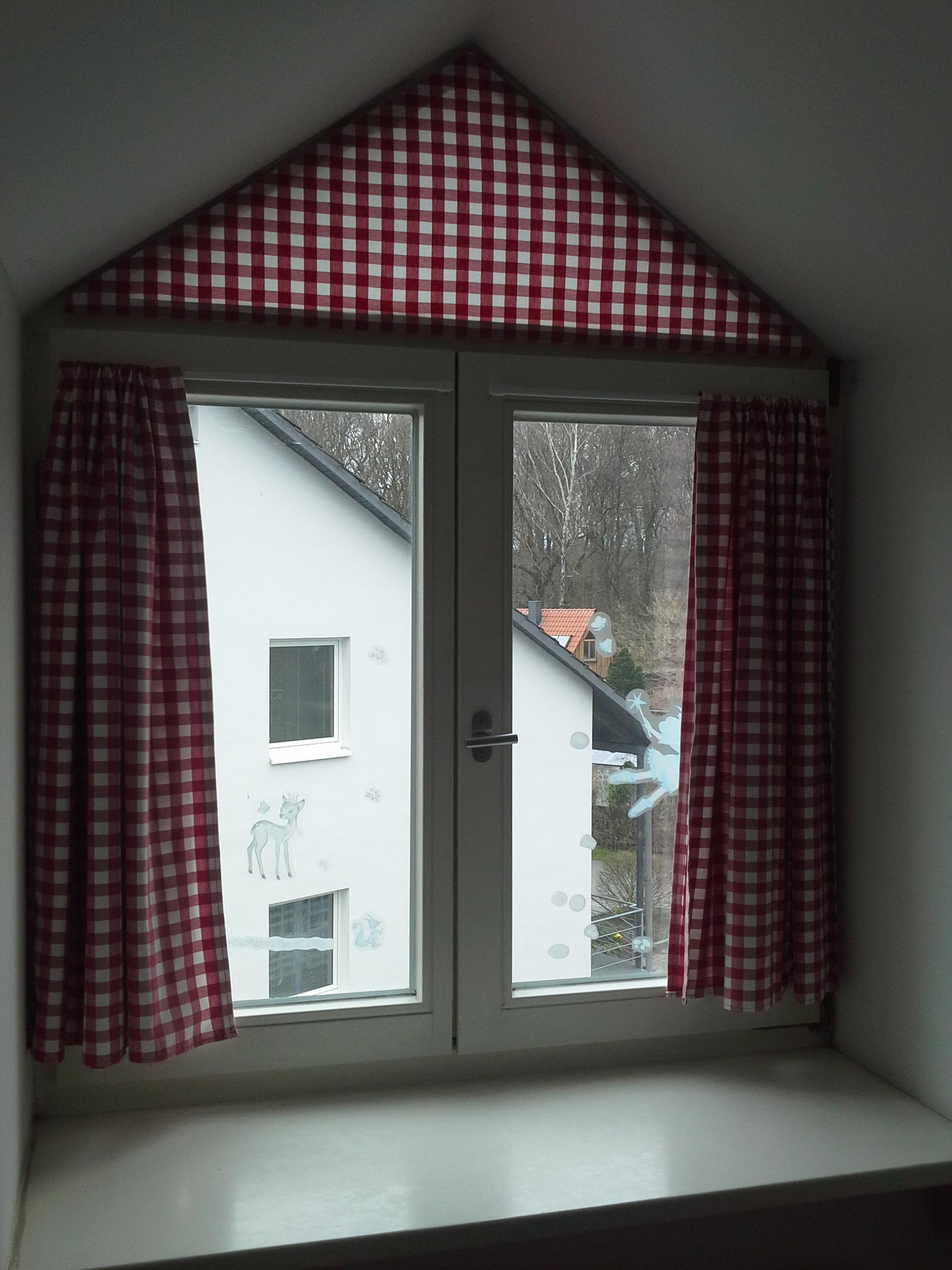 Blick aus einem Dachfenster mit roten Gardinen