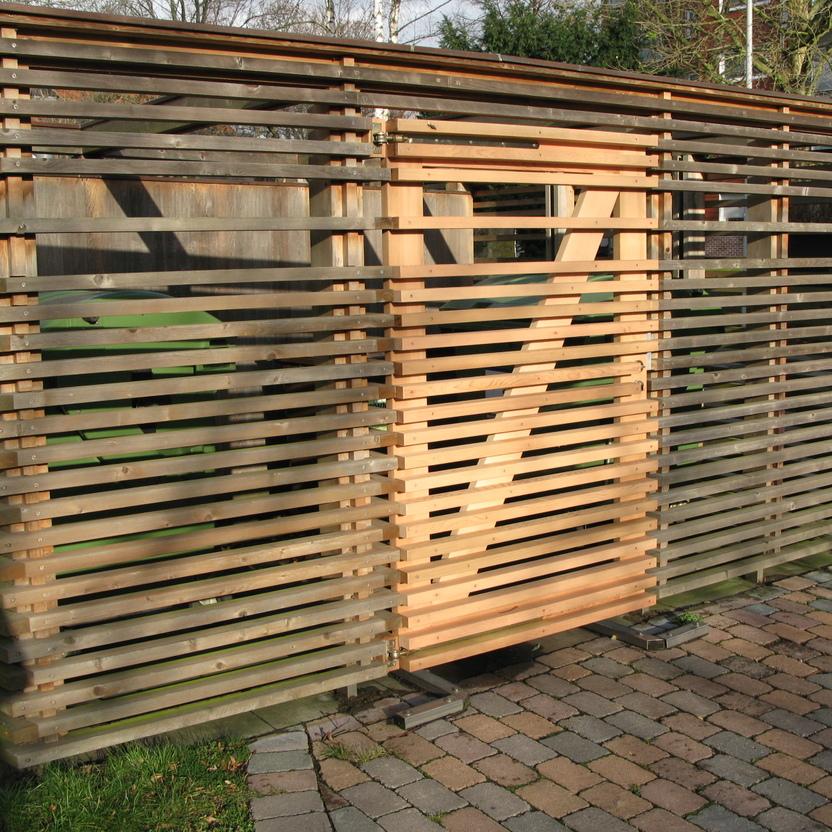 Modernes Holztor in einem urbanen Umfeld Modern gestaltetes Holztor aus horizontal und vertikal angeordneten Holzlatten, das einen halbprivaten Einblick bietet.