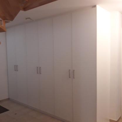 Wandschrank Großer Wandschrank aus Holz unter einer Treppe