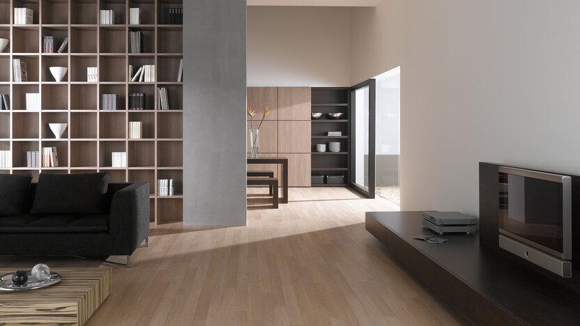 Offene Wohnraumimpression mit Einbauregal in Trennwand Offene Wohnraumimpression mit Einbauregal für Bücher und Dekoration in Trennwand mit hellem Holzboden