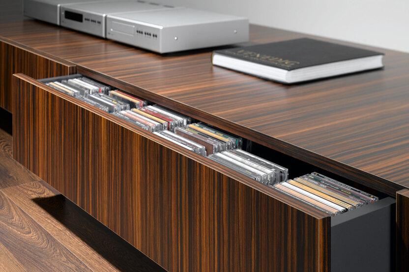 Detailaufnahme eines lackierten Sideboards mit offener Schublade für CD-Aufbewahrung