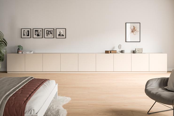 Niedriges, maßgefertigtes Sideboard in Creme, unter einer Wandgalerie aus Familienfotos, ergänzt durch minimalistische Dekoration.